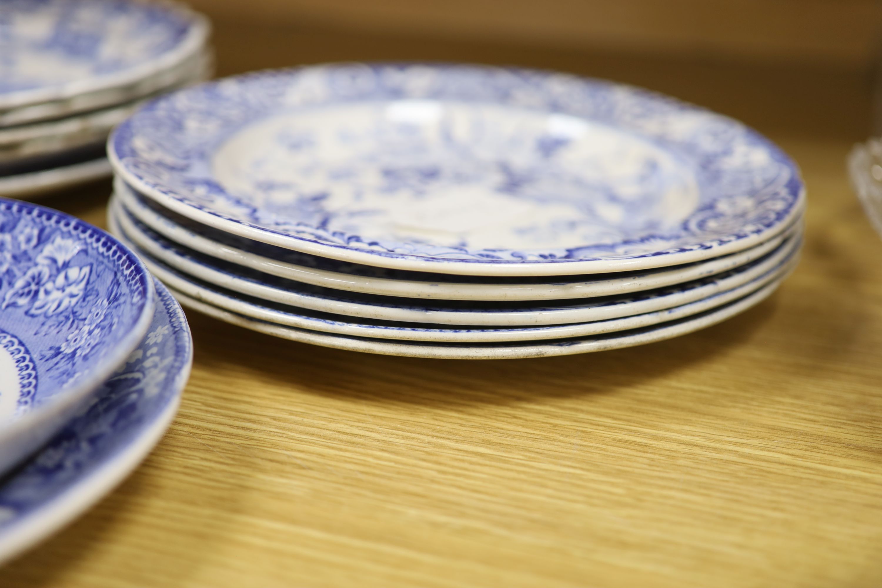 A collection of 19th and 20th century blue and white pottery plates and dishes